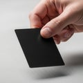 A hand holding a black rectangular object against a white background Royalty Free Stock Photo