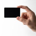 A hand holding a black rectangular object in front of a white background Royalty Free Stock Photo