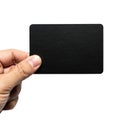 A hand holding a black rectangular object with a rough texture against a white background Royalty Free Stock Photo