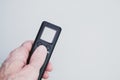 Hand holding a black remote controller on gray background for a copy space Royalty Free Stock Photo