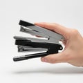 A hand holding a black and silver stapler with a partially stapled paper stack Royalty Free Stock Photo