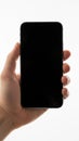 Hand holding black smartphone isolated on white background Royalty Free Stock Photo