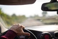 Hand holding on black steering wheel while driving in the car Royalty Free Stock Photo