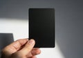Hand holding a blank black card with subtle textured details and shadows Royalty Free Stock Photo