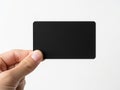 A hand holding a blank black rectangular object against a white background Royalty Free Stock Photo