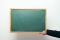 Hand holding a blank blackboard with copyspace Royalty Free Stock Photo