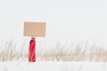 Hand holding blank board in winter field. Royalty Free Stock Photo