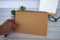Hand holding blank brown notepad with space customizable for text or ideas. Copy space for ideas Royalty Free Stock Photo