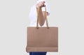 Hand holding blank brown paper shopping bag for mockup template advertising and branding isolated on white background Royalty Free Stock Photo