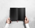 Hand holding blank opened book mock up with black pages. Royalty Free Stock Photo