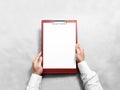Hand holding blank red clipboard with white paper design mockup Royalty Free Stock Photo