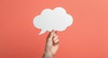 Hand holding blank speech bubble on coral background Royalty Free Stock Photo