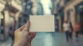 Hand Holding Blank White Card in Busy Street Setting During Daytime Royalty Free Stock Photo