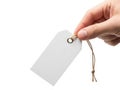 A hand holding a blank white tag with a string attached to it Royalty Free Stock Photo