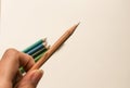 A hand holding a blending pencil for colored pencils with several colored pencils in the background Royalty Free Stock Photo