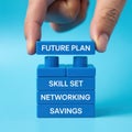 Hand holding blue block with future plan text over a stack of blue blocks with skill set networking Royalty Free Stock Photo