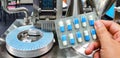 Hand holding blue capsule pack at medicine pill production line Royalty Free Stock Photo