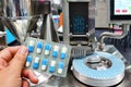 Hand holding blue capsule pack at medicine pill production line Royalty Free Stock Photo