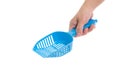 hand holding Blue cat litter scoop on white background 