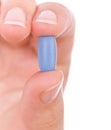 Hand holding a blue pill Royalty Free Stock Photo