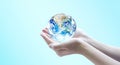 Hand holding blue planet earth globe with blurred background . Elements of this image furnished by NASA. Royalty Free Stock Photo