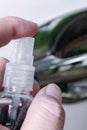 Hand holding a bottle of alcohol spraying on the car door handle to sterilize it. During the covid-19 epidemic Royalty Free Stock Photo