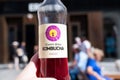 hand holding bottle of Carpe Diem Kombucha drink on hot day in a busy city street