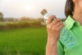 Hand holding bottle water with green field background,Summer holiday vacation outdoor and view in evening,Drinks, people and Royalty Free Stock Photo