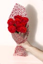 Hand holding bouquet of red roses over white background Royalty Free Stock Photo