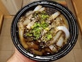 Hand holding bowl of Chinese bean starch noodles