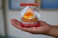 Hand holding bread Foi Thong Cake Fios de ovos put in plastic bags, home-made sweets,