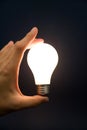 Hand holding a Bright Light Bulb Royalty Free Stock Photo