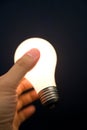 Hand holding a Bright Light Bulb Royalty Free Stock Photo