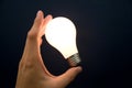 Hand holding a Bright Light Bulb Royalty Free Stock Photo