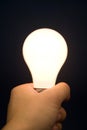 Hand holding a Bright Light Bulb Royalty Free Stock Photo