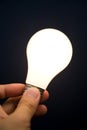 Hand holding a Bright Light Bulb Royalty Free Stock Photo