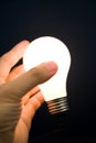 Hand holding a Bright Light Bulb Royalty Free Stock Photo