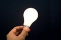Hand holding a Bright Light Bulb Royalty Free Stock Photo