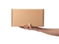 A hand holding a brown cardboard box against a white background Royalty Free Stock Photo