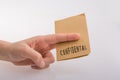 Hand holding a brown color paper with text confidental Royalty Free Stock Photo