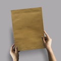 Hand holding brown pack document for Mock up design