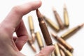 Hand holding a bullet shell casing with more in the background Royalty Free Stock Photo