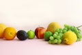 Fresh fruit apple, lime, avocado, lemon, orange, grapes on a light pink background Royalty Free Stock Photo