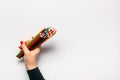 A hand holding a bunch of wooden crayons on white background