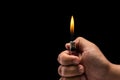 Hand holding burning gas lighter. Studio shot isolated on black Royalty Free Stock Photo