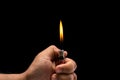 Hand holding burning gas lighter. Studio shot isolated on black Royalty Free Stock Photo