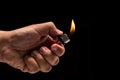 Hand holding burning gas lighter. Studio shot isolated on black Royalty Free Stock Photo