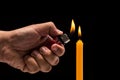 Hand holding burning gas lighter to light candle. Studio shot is Royalty Free Stock Photo