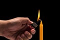 Hand holding burning gas lighter to light candle. Studio shot is Royalty Free Stock Photo