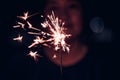 Hand holding burning Sparkler blast on a black background at night,holiday celebration event party,dark vintage tone. Royalty Free Stock Photo